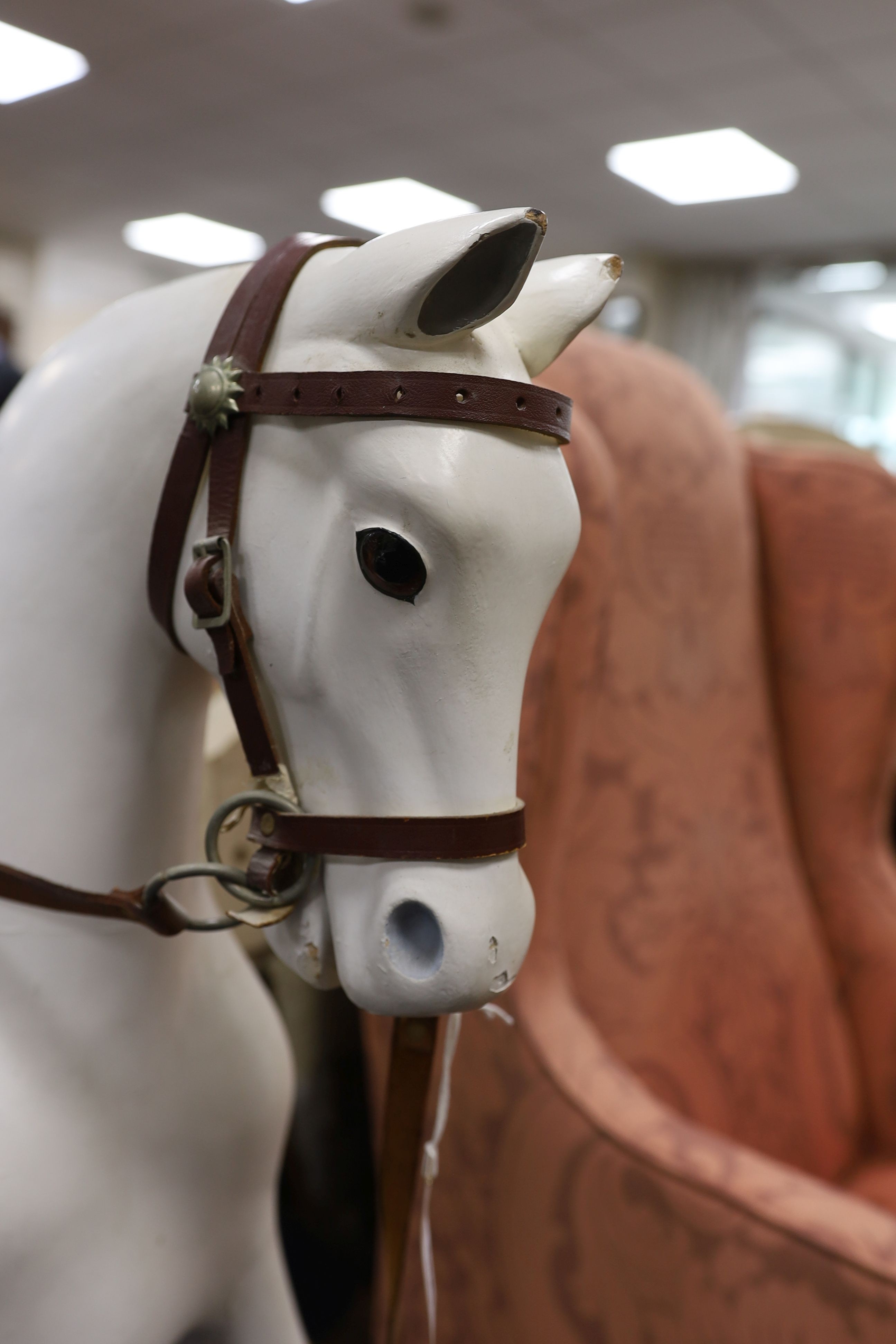 An early 20th century rocking horse on painted safety frame, (re-painted) width 126cm, height 114cm
